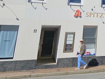Praxiseingang Kathrin Ortinger Naujeck am Marktplatz 1 in Prien Fassade des Geschäftshauses am Marktplatz 1 mit Schild Physiotherapie Kathrin Ortinger Naujeck und Spitzwegapotheke